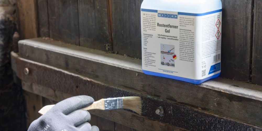 Rostentferner Gel wird auf Metalstange in einem Stall gestrichen