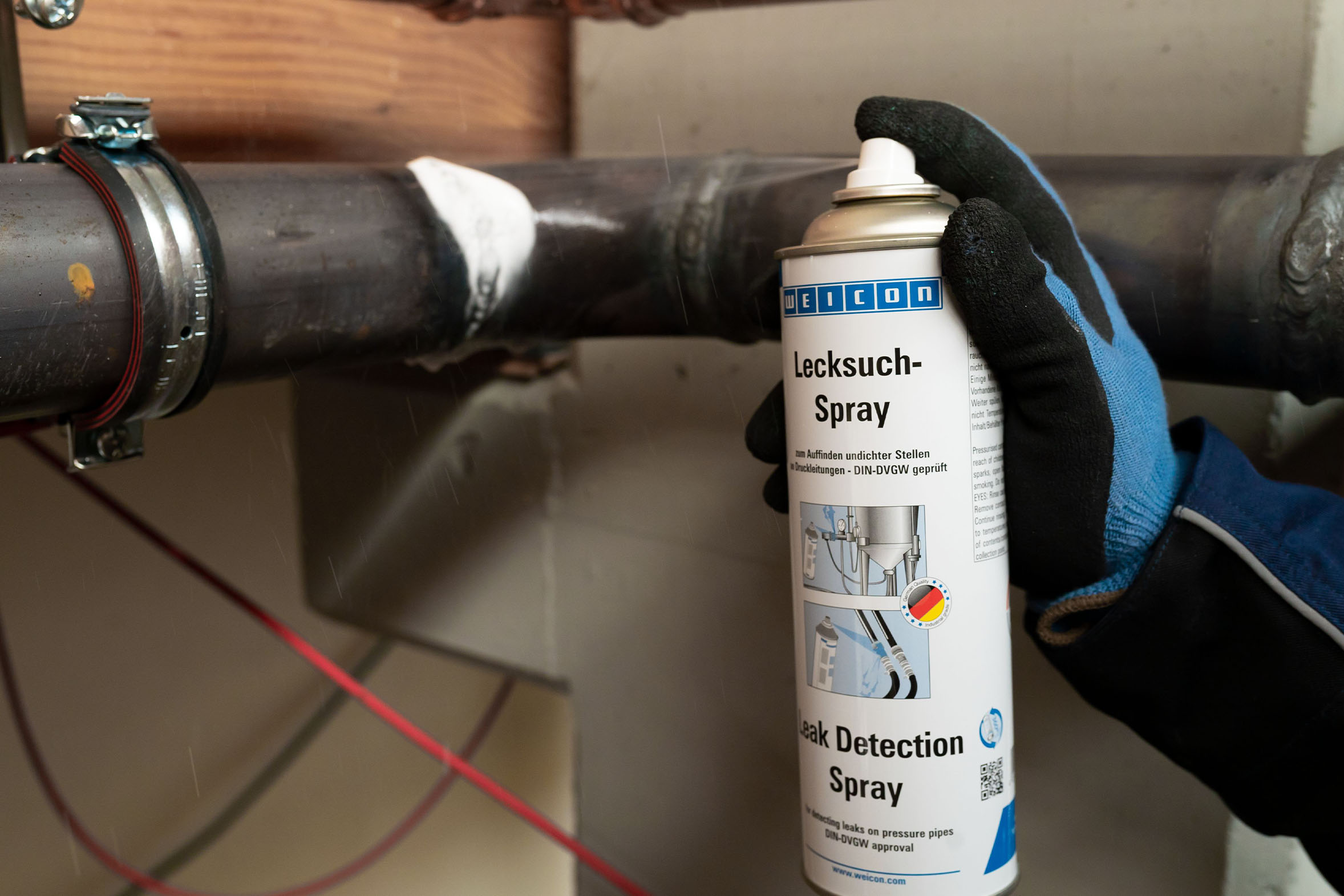 Weicon Lecksuch-Spray wird auf Rohr gesprüht