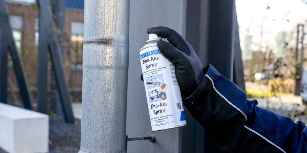 Zink-Alu-Spray wird auf Regenrinne gesprüht