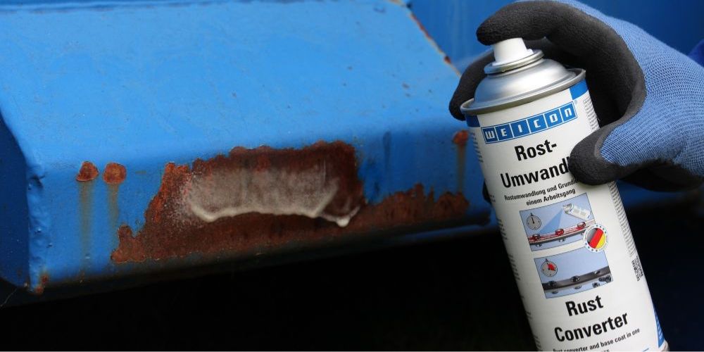 Rostumwandler wird auf blaues Metallteil mit Korrosion gesprüht