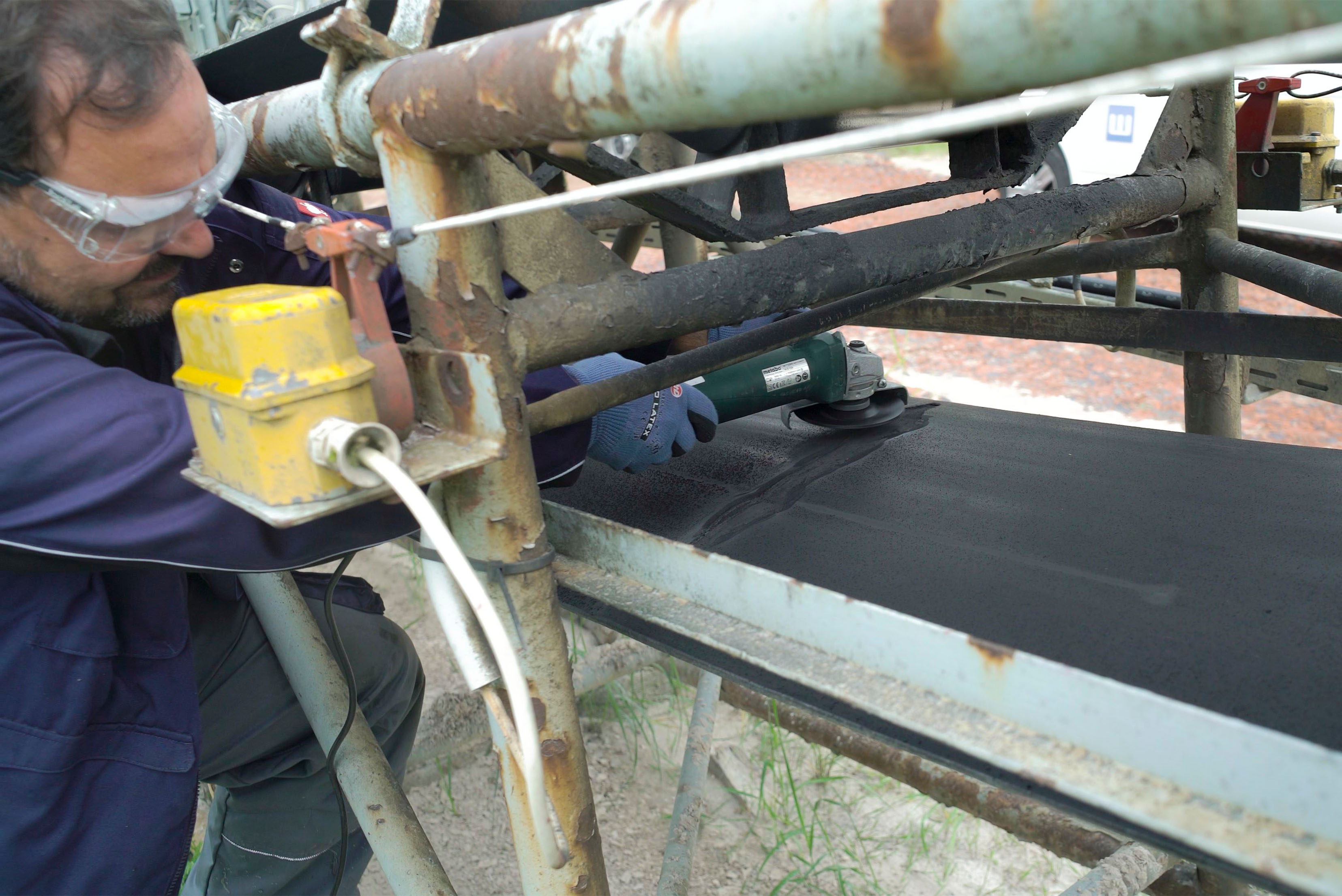 Mann, der ein Förderband repariert