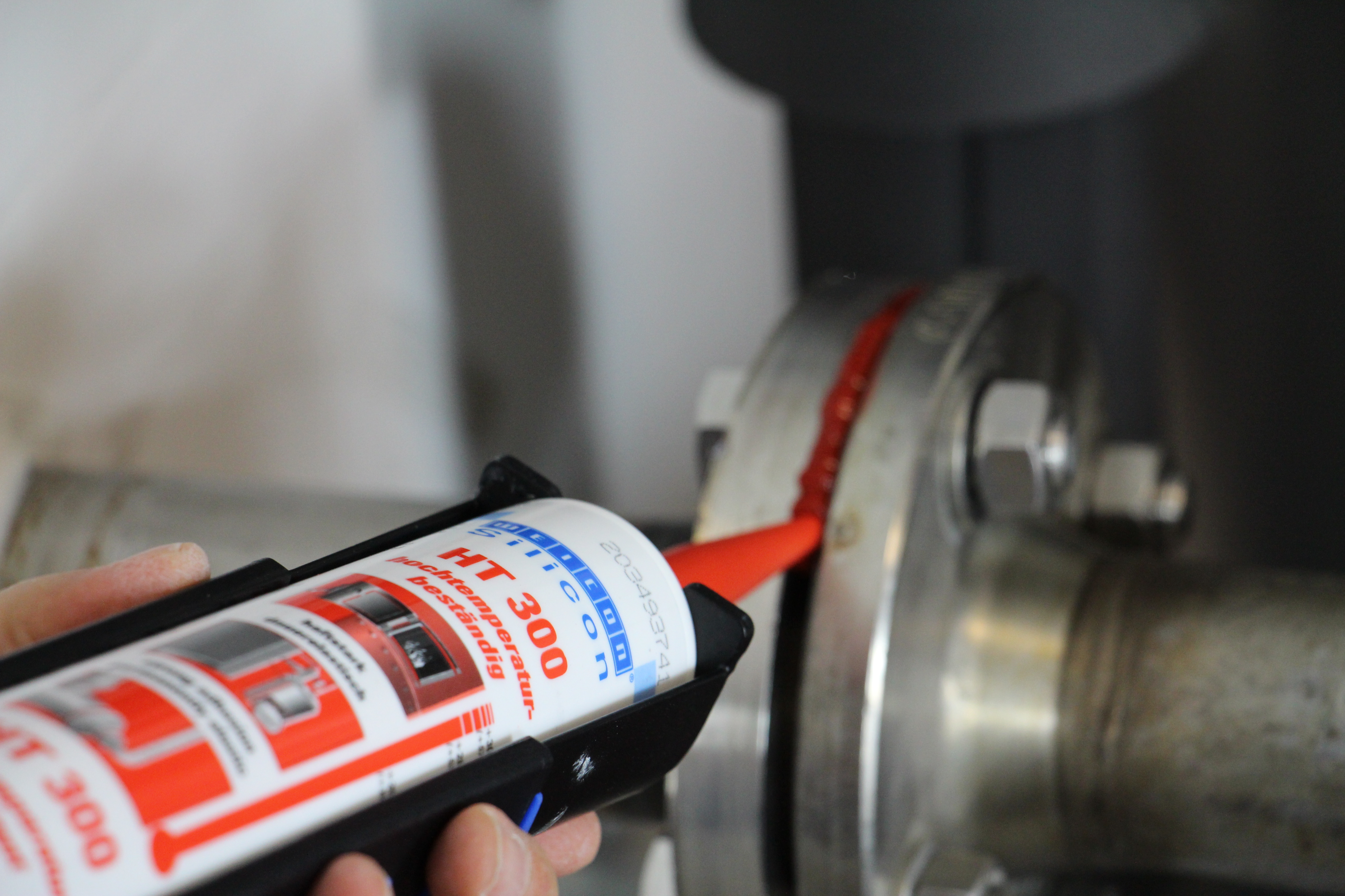 Silikon HT 300 wird auf ein Metallteil aufgetragen