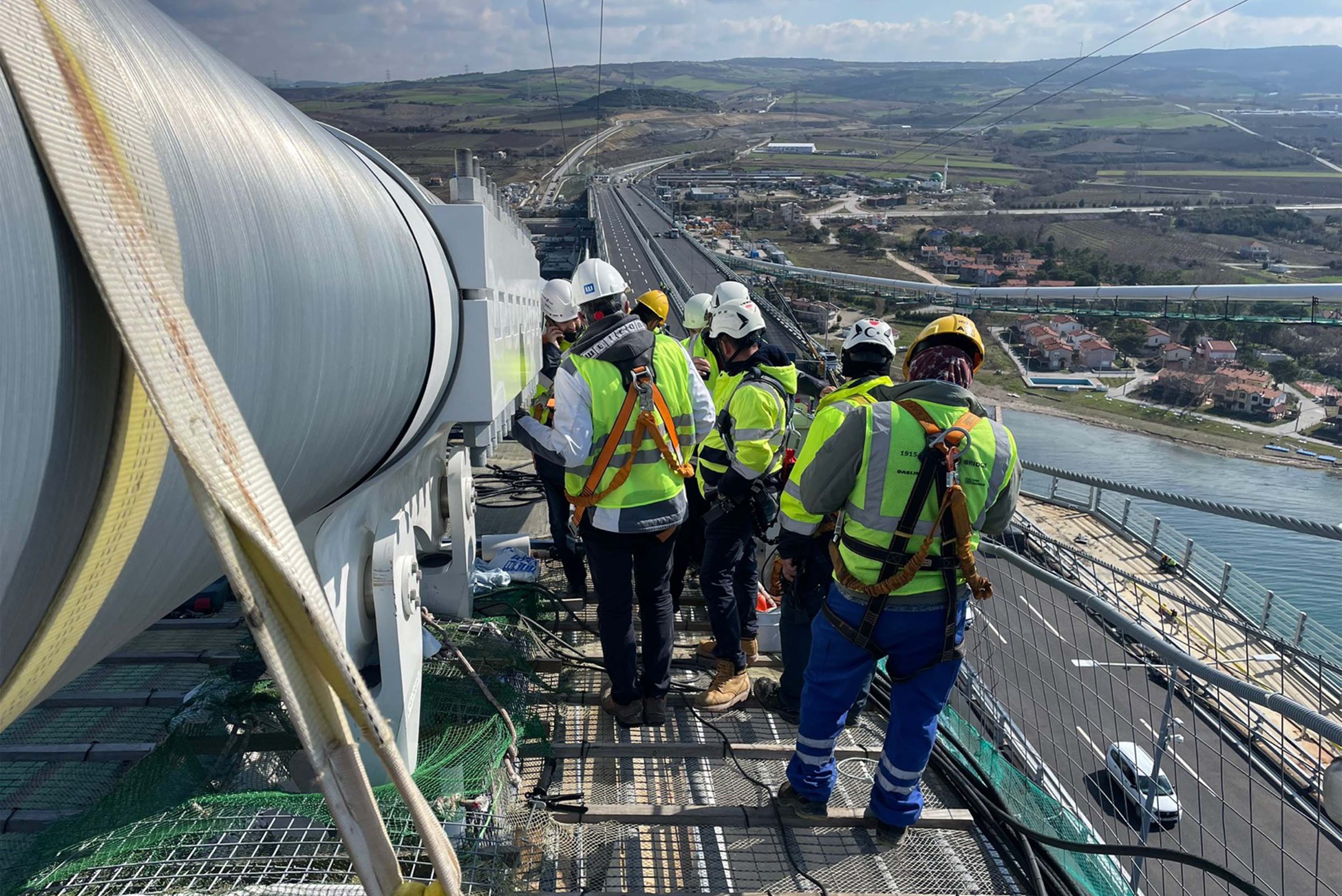 mehrer Männer in Arbeitskleidung auf einer Baustelle an einem großen Rohr