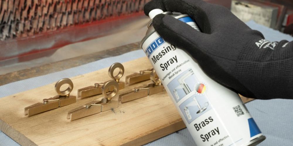 Messing-Spray wird auf Kleideraken gesprüht