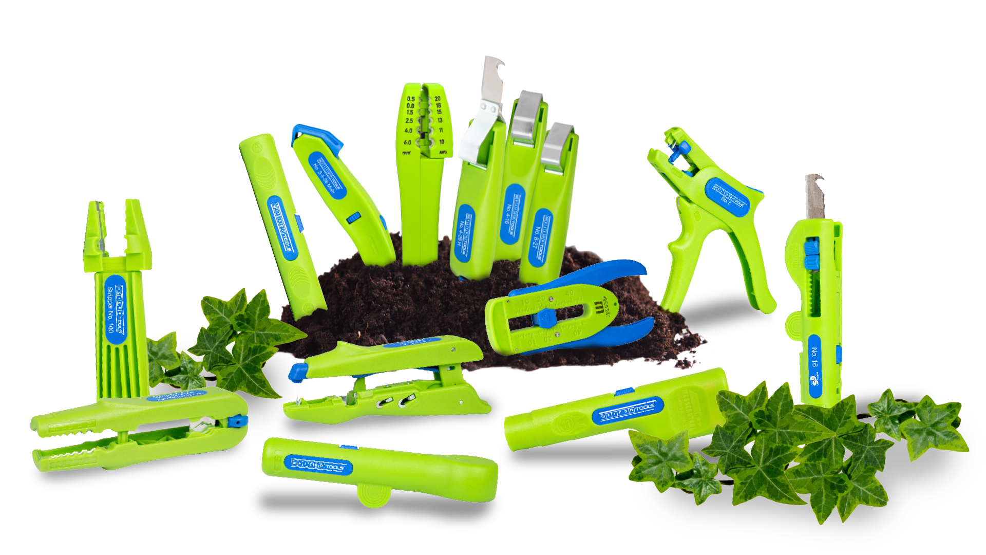 Gruppenbild der Weicon Tools Green Line. Einige stecken in einem Erdhauen, vorne und hinten liegt jeweils ein Stück Efeu