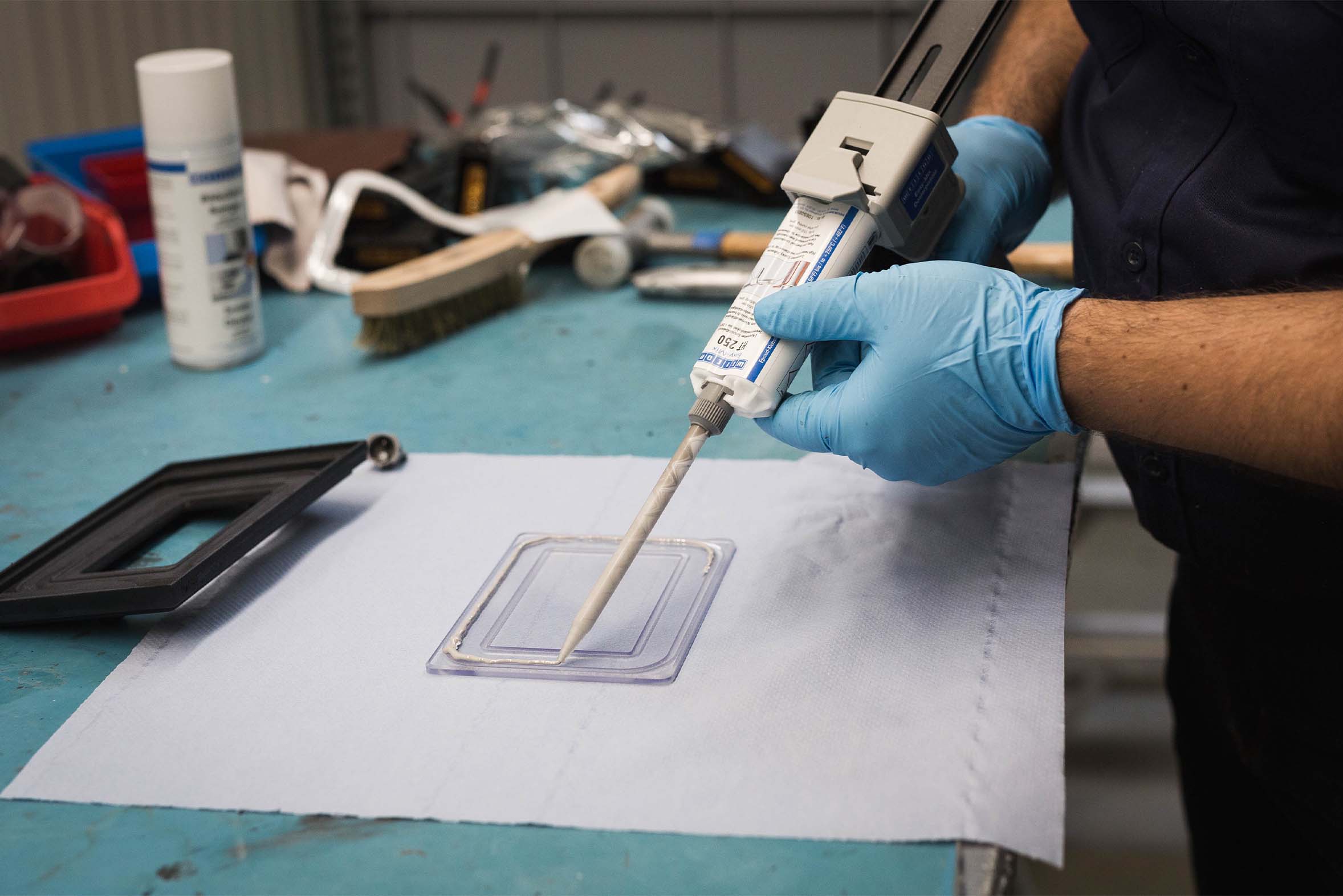 Weicon HT 250 wird auf Plexiglasscheibe aufgetragen