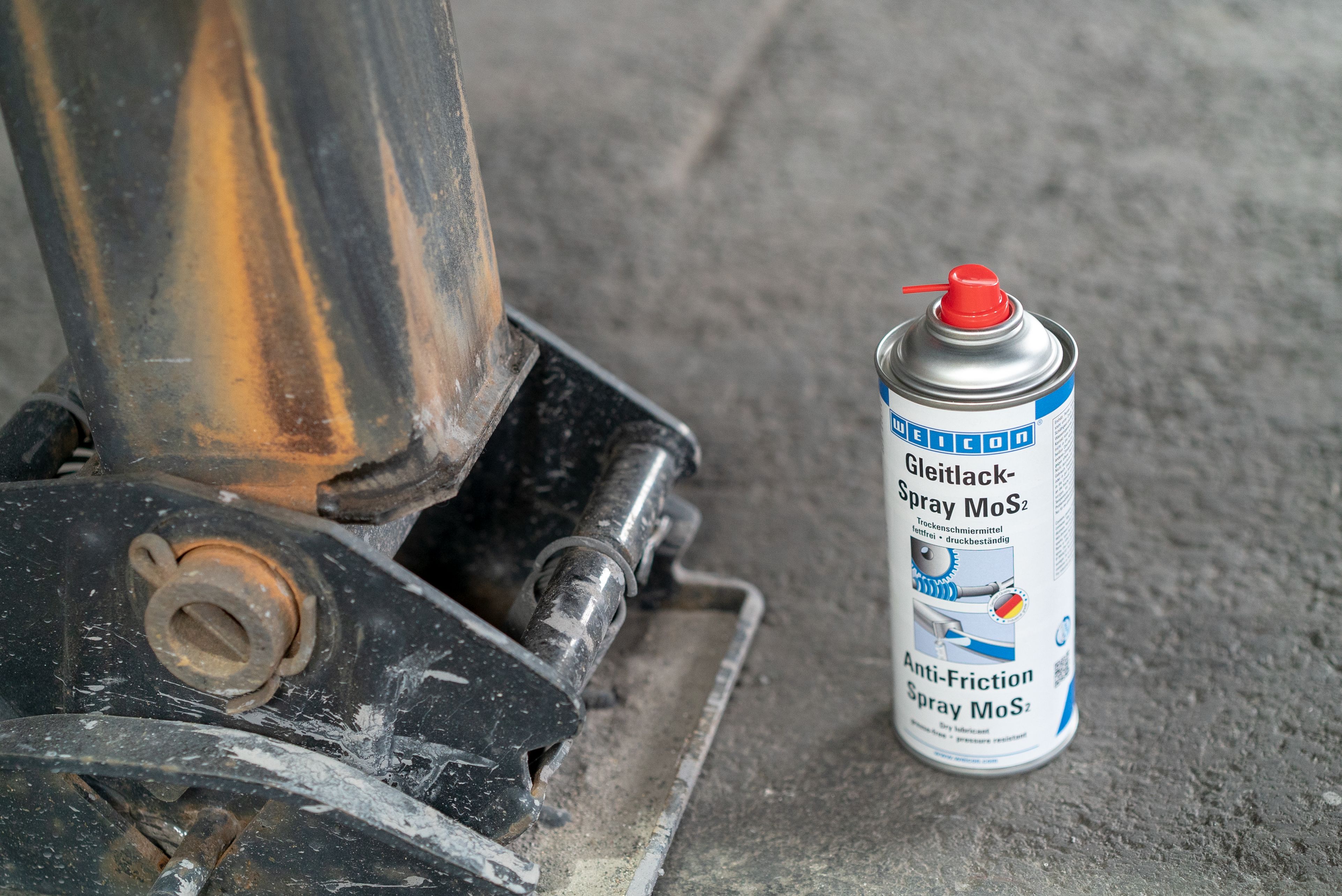 Links ist ein schwarzer MEtallpfosten und rechts steht das Weicon Gleitlackspray Mos2