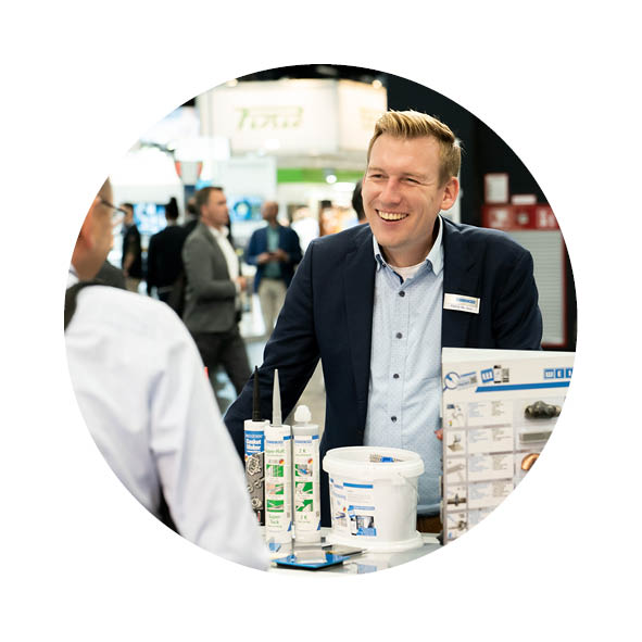 2 Männer stehen am Messestand von Weicon und unterhalten sich