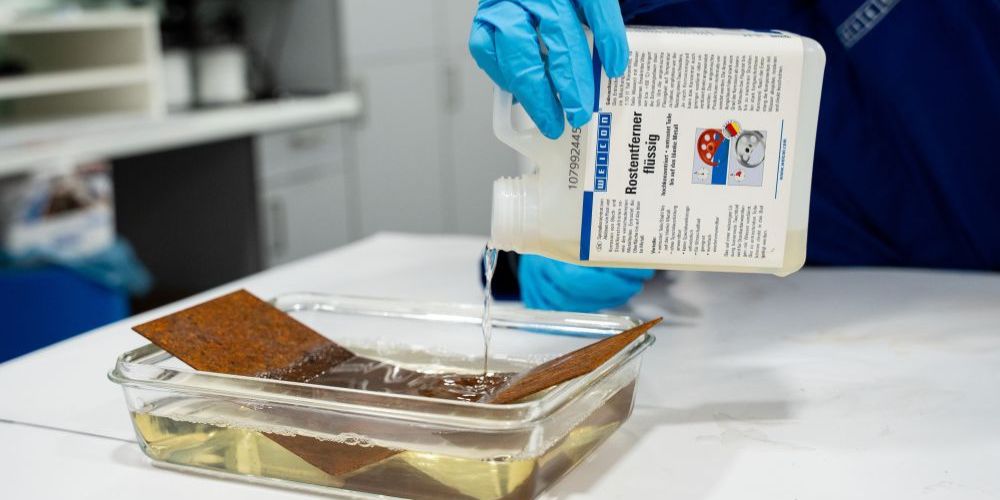 Flaches Metallblat liegt im Rostentferner Tauchbad