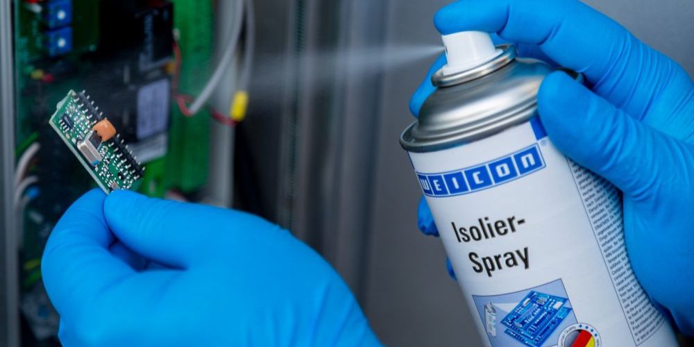 Kleine Platine wird mit Isolierspray besprüht