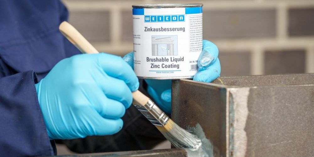Zinkausbesserung wird auf Metallblock gepinselt