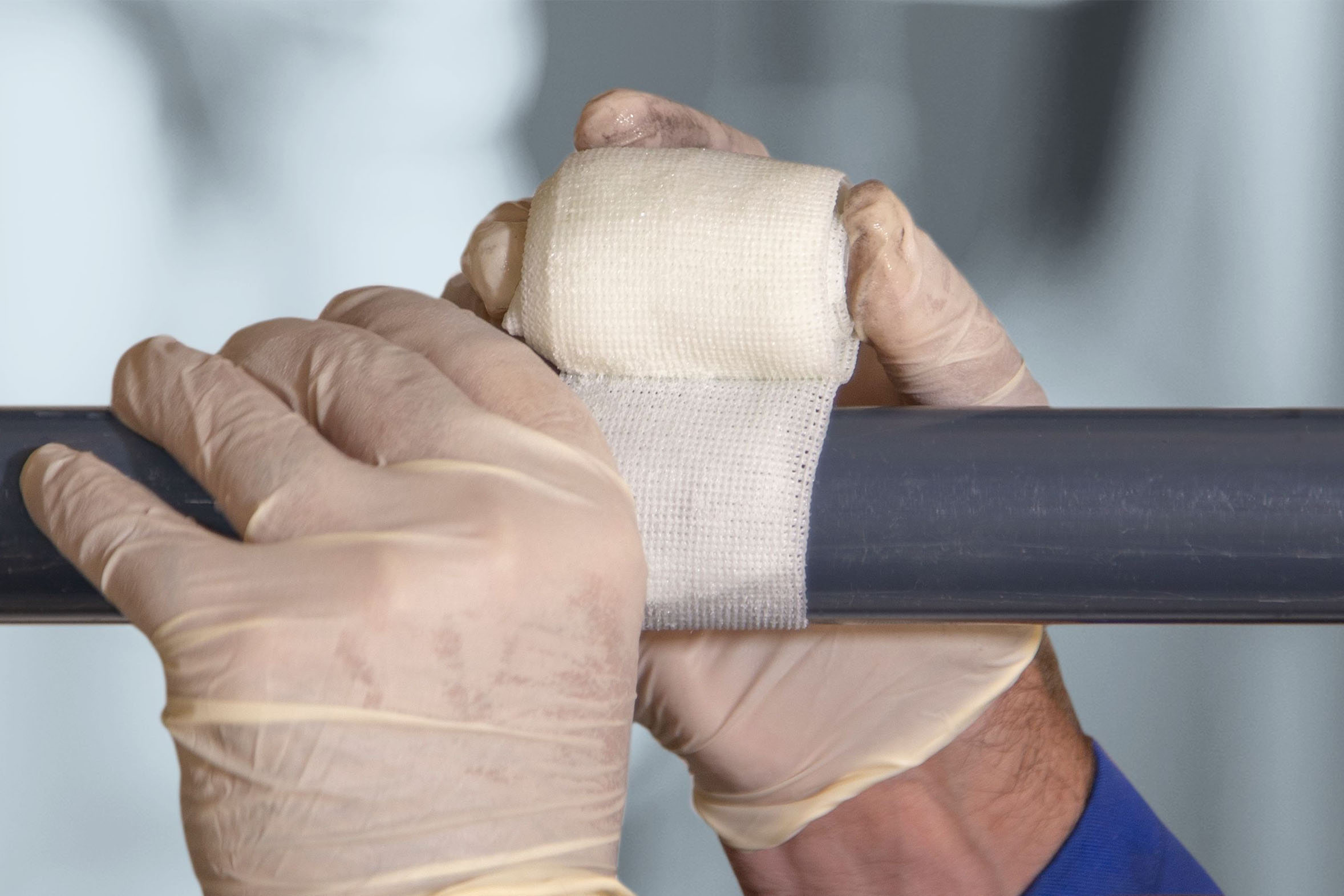 weißes Reparaturband wird um Rohr gewickelt